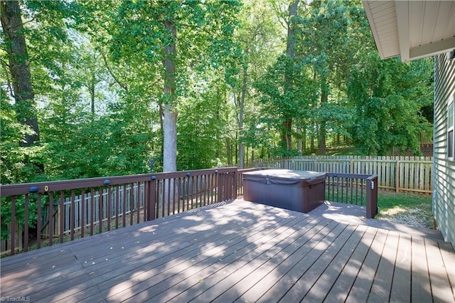 deck with a fenced backyard and a hot tub