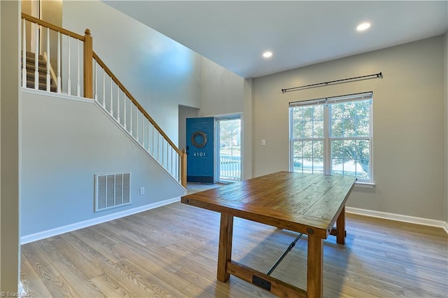 unfurnished dining area with visible vents, wood finished floors, stairway, baseboards, and recessed lighting