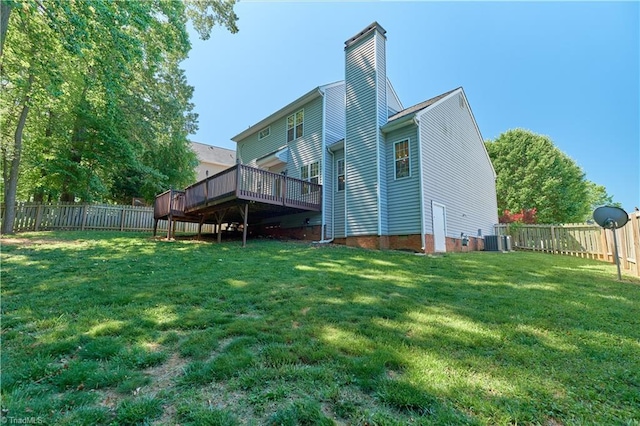 back of property with a chimney, a fenced backyard, a deck, and central AC unit