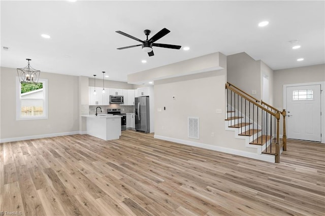 3630 Old Vineyard Rd, Winston-Salem, NC 27104 - unfurnished living room with a sink, light wood-style floors, baseboards, stairway, and recessed lighting