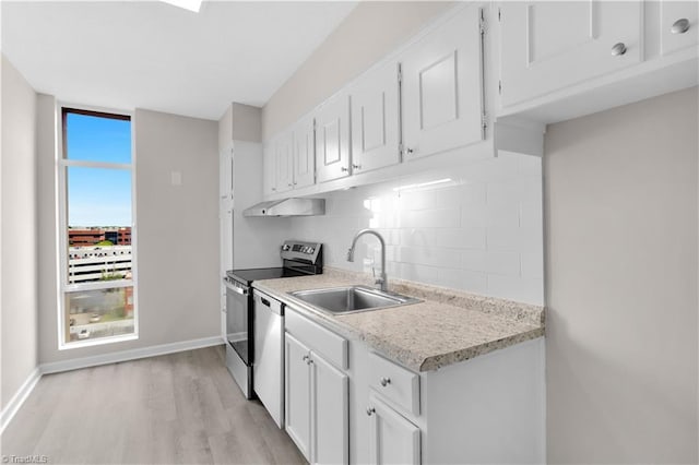 1101 N Elm St Unit 904, Greensboro, NC 27401 - kitchen with a sink, stainless steel appliances, backsplash, light countertops, and light wood-style flooring
