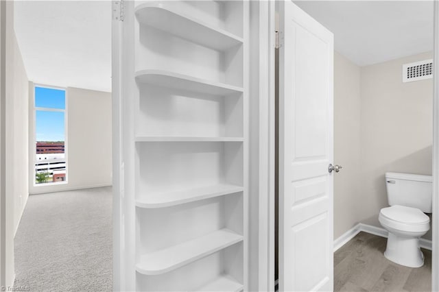 1101 N Elm St Unit 904, Greensboro, NC 27401 - bathroom with baseboards, toilet, and wood finished floors