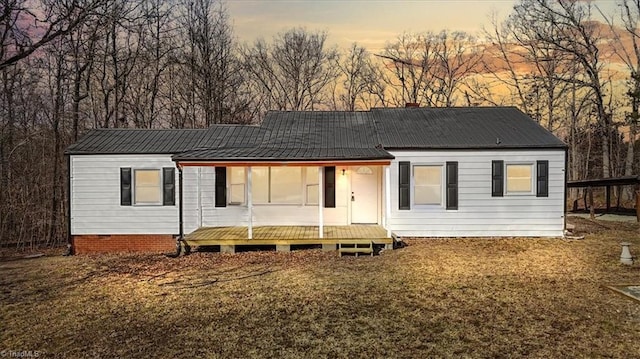 back house at dusk featuring a yard