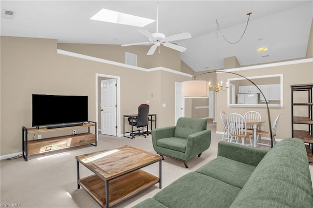 living area with a chandelier, a skylight, carpet flooring, high vaulted ceiling, and a ceiling fan