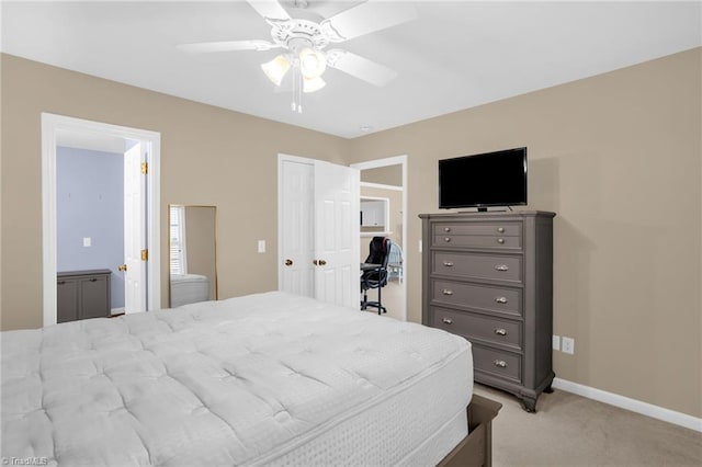 bedroom featuring light colored carpet, a closet, a ceiling fan, baseboards, and connected bathroom
