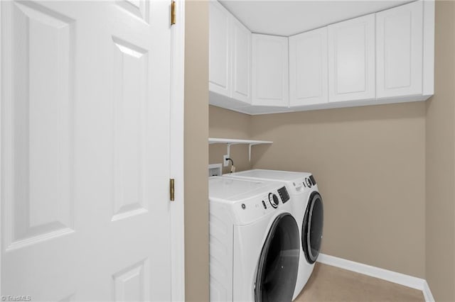 clothes washing area with washer and dryer, cabinet space, baseboards, and light tile patterned floors