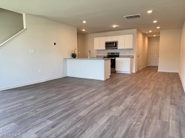 2210 Cranberry Way, Salisbury, NC 28147 - kitchen featuring appliances with stainless steel finishes, white cabinets, dark wood-type flooring, recessed lighting, and a peninsula
