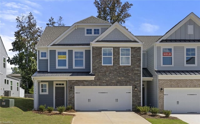 craftsman house featuring a garage, a front yard, and central AC