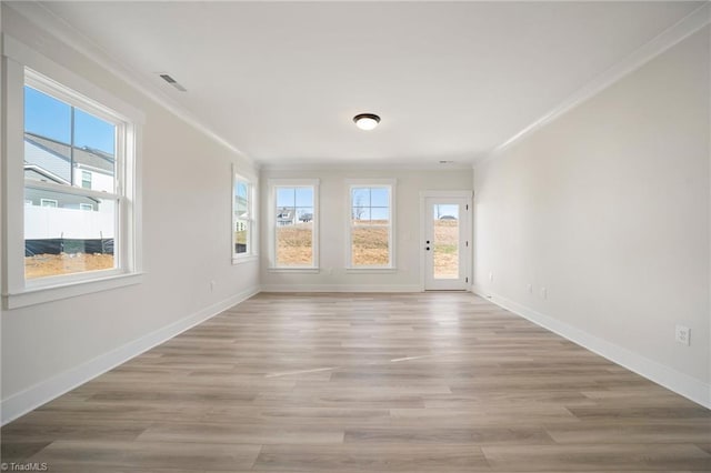 unfurnished room with a wealth of natural light, light hardwood / wood-style flooring, and ornamental molding