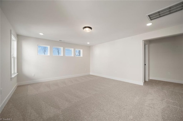 empty room with a wealth of natural light and carpet