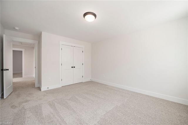 unfurnished bedroom with a closet and light carpet