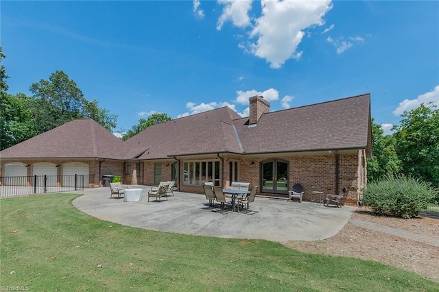 rear view of property featuring french doors, a patio, and a lawn