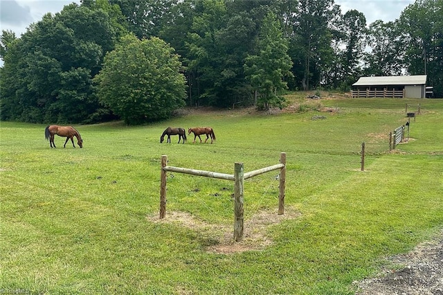 view of property's community with a rural view and a lawn