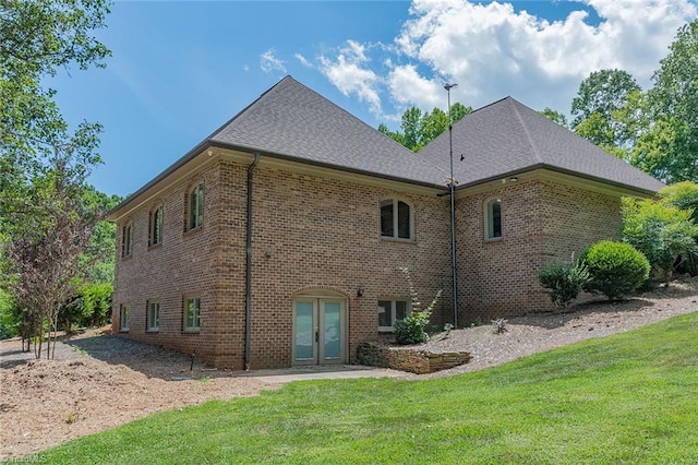 back of house with french doors and a yard