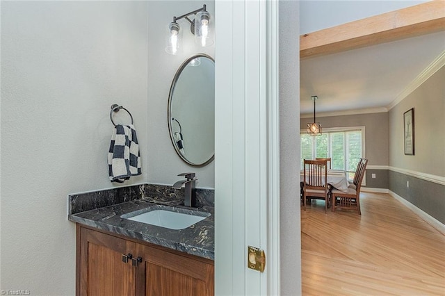 bathroom featuring crown molding, vanity, and wood-type flooring