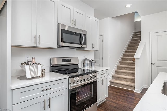 kitchen featuring appliances with stainless steel finishes, white cabinets, and dark hardwood / wood-style flooring