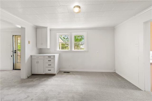 interior space with crown molding, baseboards, and light carpet