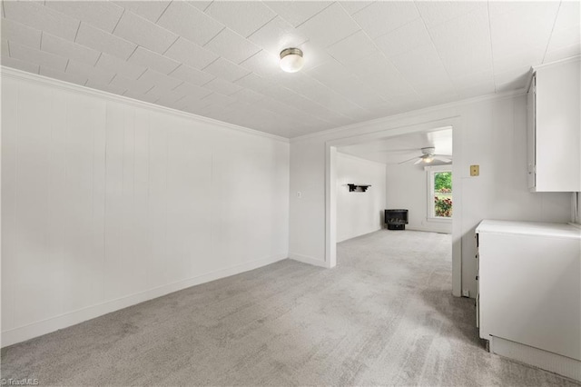 unfurnished living room with light colored carpet, ceiling fan, and crown molding