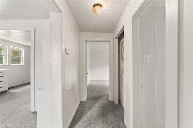 hall with crown molding, carpet flooring, and visible vents