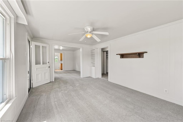 interior space featuring ornamental molding, ceiling fan, and carpet floors