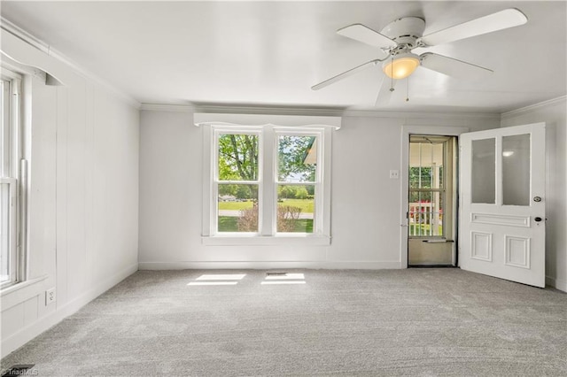 unfurnished room featuring carpet flooring, a wealth of natural light, and crown molding