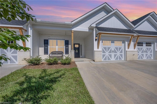 3903 Sudley Pt Unit 18, Jamestown, NC 27282 - view of front of home with brick siding, driveway, covered porch, an attached garage, and board and batten siding