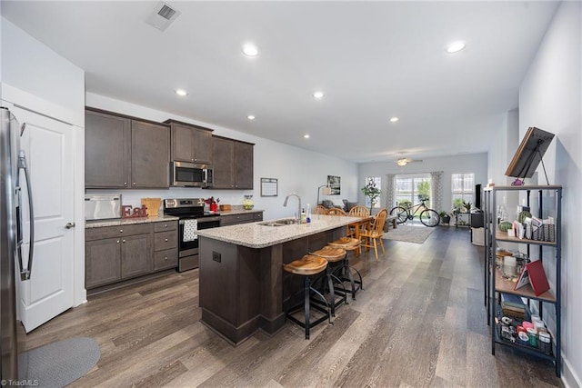 3903 Sudley Pt Unit 18, Jamestown, NC 27282 - kitchen with appliances with stainless steel finishes, dark brown cabinets, dark wood-type flooring, a kitchen breakfast bar, and an island with sink