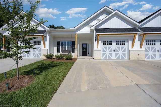 3903 Sudley Pt Unit 18, Jamestown, NC 27282 - view of front of home with brick siding, a garage, driveway, board and batten siding, and a front lawn