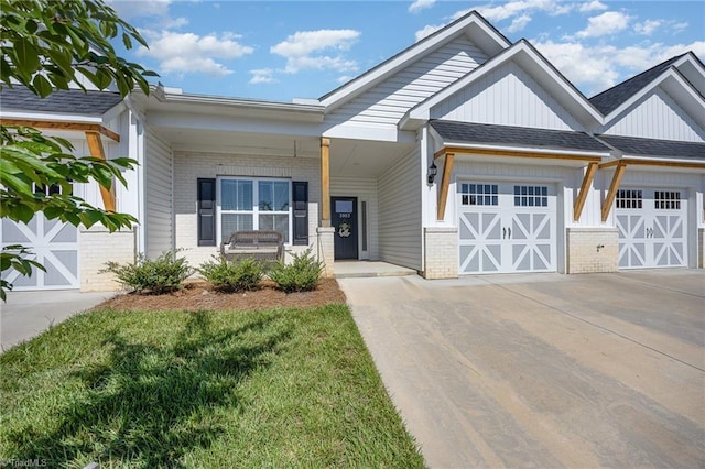 3903 Sudley Pt Unit 18, Jamestown, NC 27282 - view of front of home with brick siding, concrete driveway, an attached garage, a porch, and board and batten siding