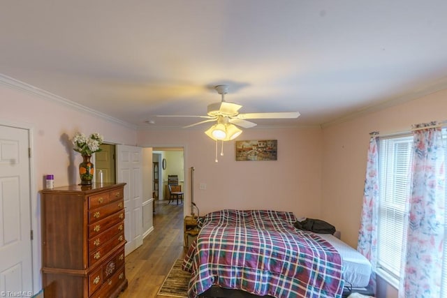 bedroom featuring multiple windows, crown molding, light hardwood / wood-style floors, and ceiling fan