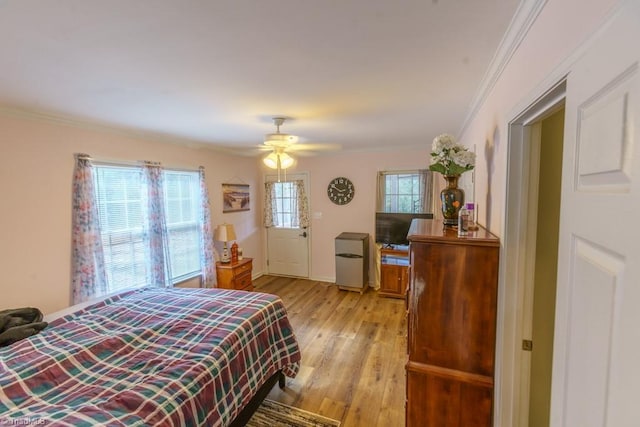 bedroom with ornamental molding, ceiling fan, and light hardwood / wood-style floors