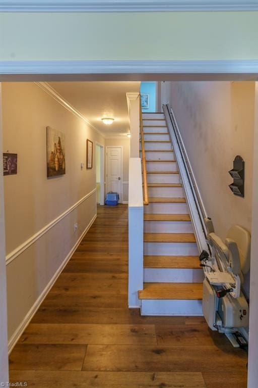 stairs featuring crown molding and hardwood / wood-style floors