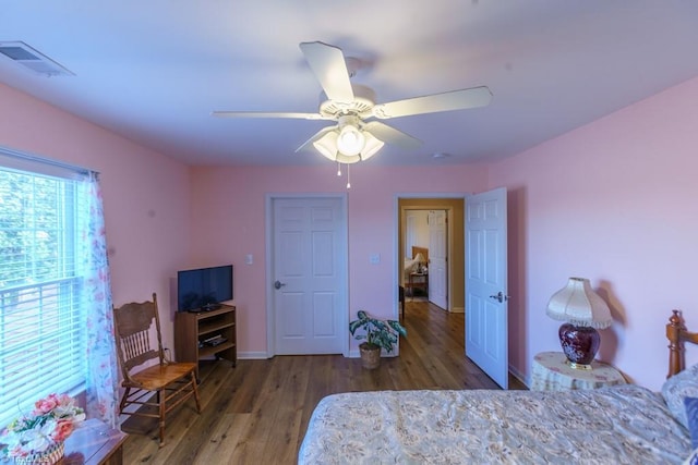 bedroom with dark hardwood / wood-style floors and ceiling fan