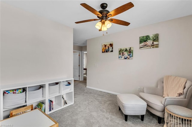 sitting room featuring baseboards, ceiling fan, and carpet floors