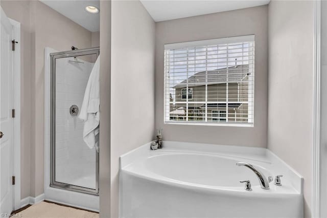 bathroom with a bath and a shower stall