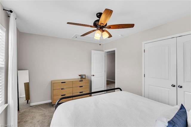 carpeted bedroom with a closet, baseboards, and a ceiling fan