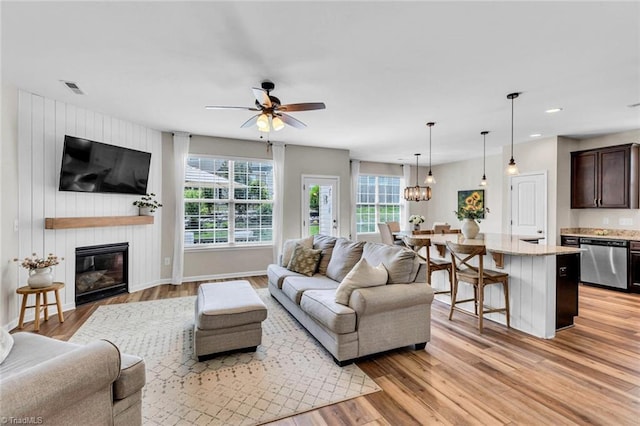 living area with visible vents, recessed lighting, light wood finished floors, a large fireplace, and a ceiling fan