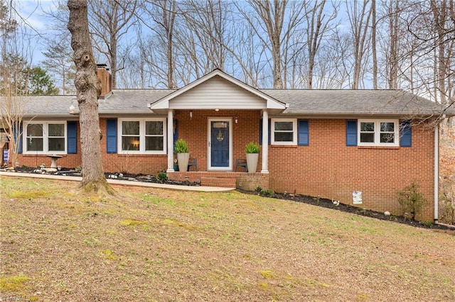 ranch-style home featuring roof with shingles, a chimney, a front lawn, crawl space, and brick siding