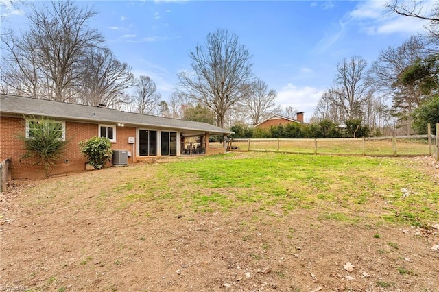 view of yard with central AC unit and a fenced backyard