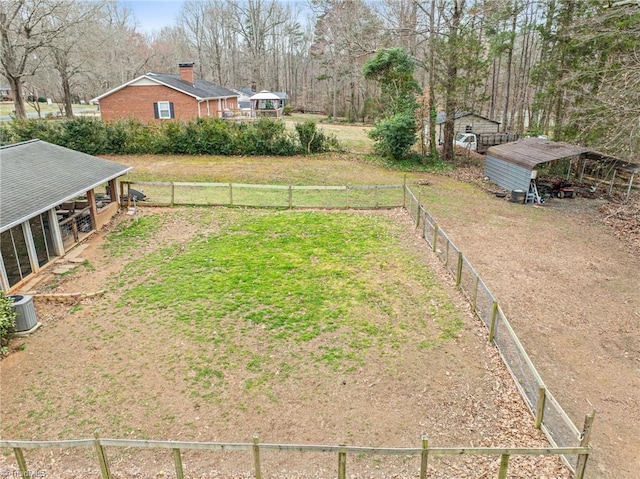 view of yard with central AC and fence