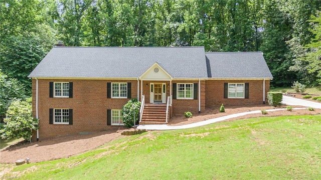 4904 Landaff Dr, Greensboro, NC 27406 - view of front of house with a front yard, brick siding, and a chimney