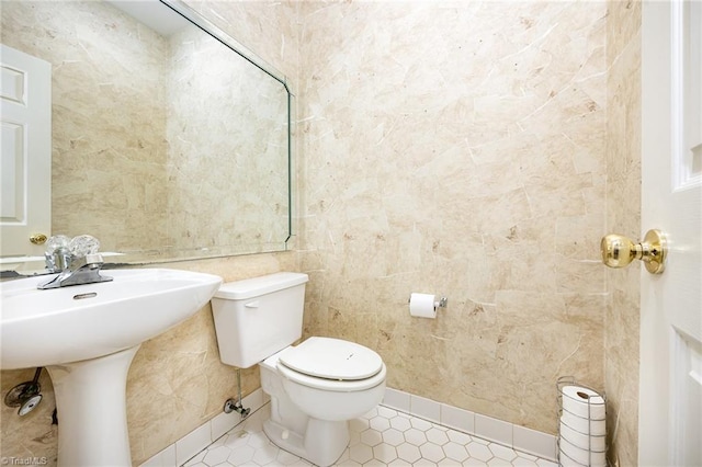 4904 Landaff Dr, Greensboro, NC 27406 - half bath featuring tile patterned floors, toilet, tile walls, and a sink