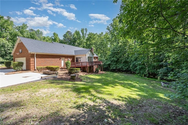 4904 Landaff Dr, Greensboro, NC 27406 - back of property featuring a garage, a deck, brick siding, and a yard