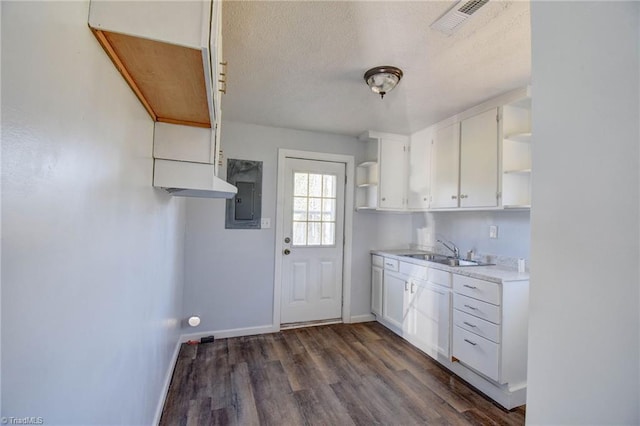 kitchen featuring white cabinets, a textured ceiling, dark hardwood / wood-style flooring, and sink