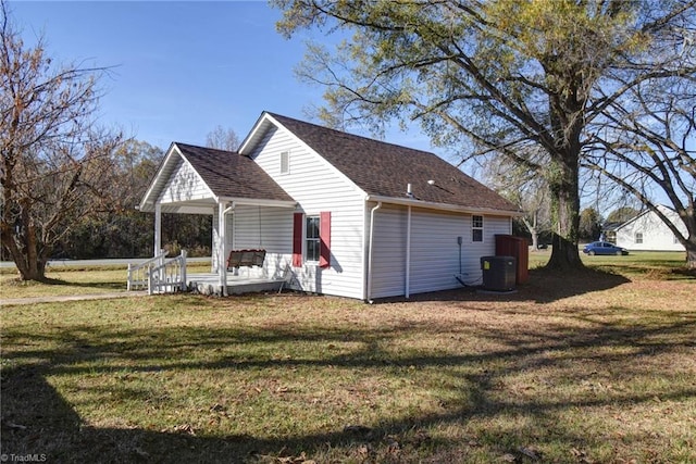 back of house with central AC and a lawn