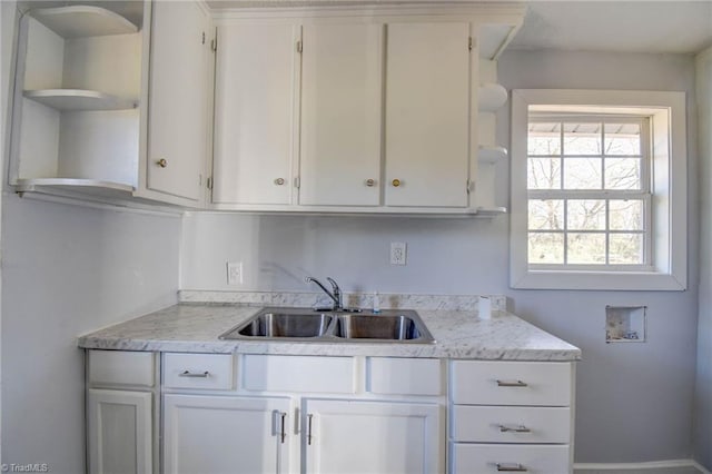 kitchen featuring white cabinetry and sink