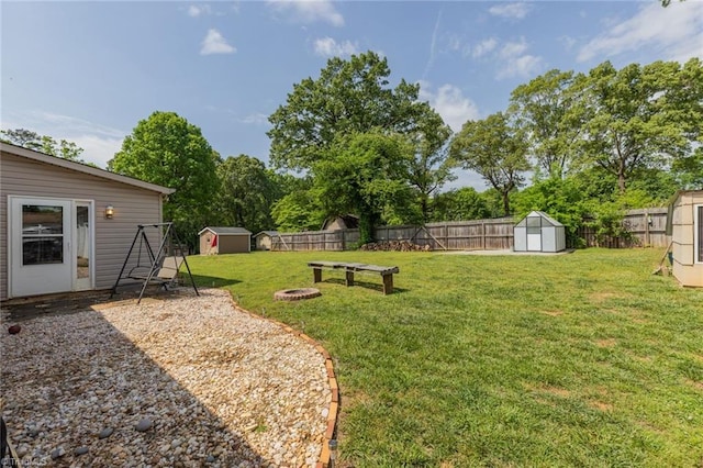 view of yard with a fenced backyard, an outdoor structure, and a shed