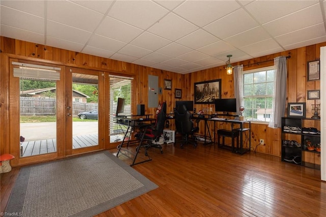 office featuring french doors, wood walls, a drop ceiling, and wood finished floors