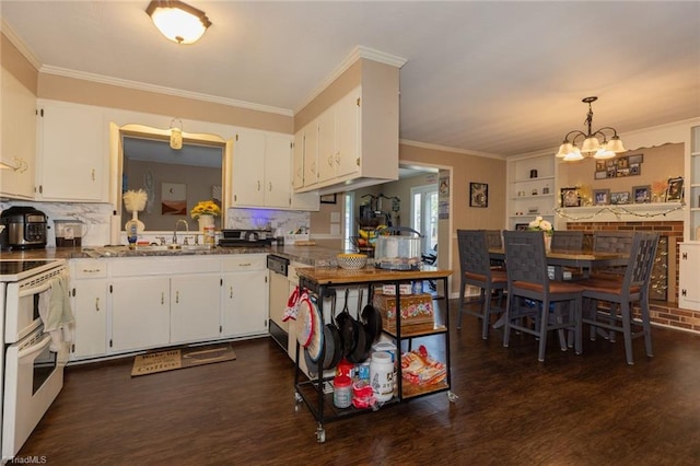 kitchen with an inviting chandelier, a sink, dark wood finished floors, double oven range, and ornamental molding