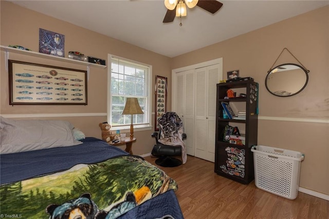 bedroom with baseboards, a ceiling fan, a closet, and wood finished floors